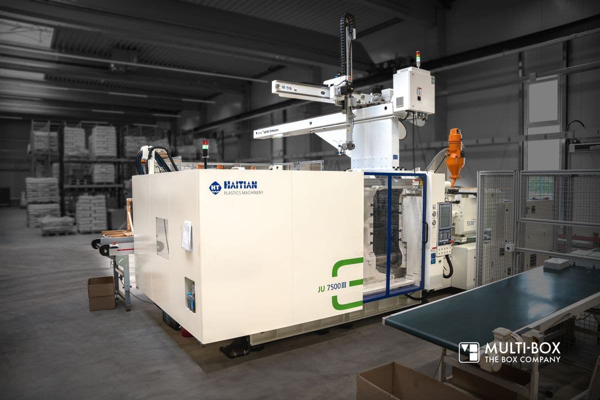 Blick auf eine moderne Spritzgussmaschine für Industriegehäuse in einer Fertigunghalle.