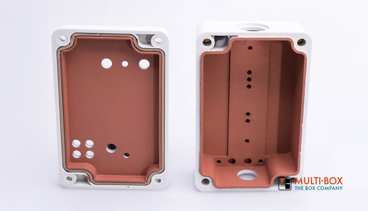 Two enclosures with internal protective material, one with holes and drillings for industrial applications.